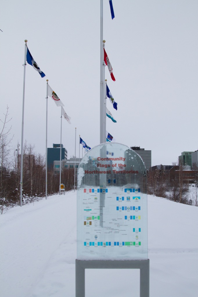 Flags of the NWT communities, with downtown in the background.